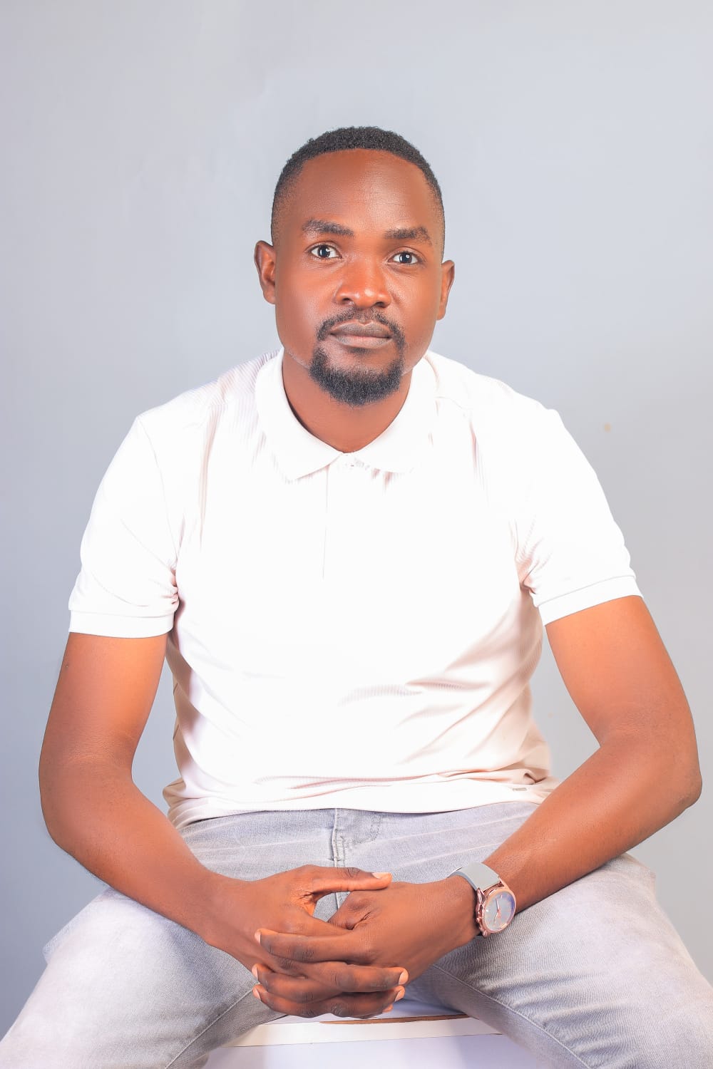 Dismus Nganyi seated, wearing a white polo shirt